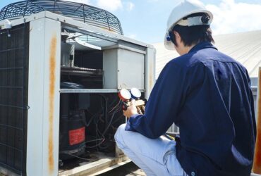 Modern HVAC technician inspecting an industrial air conditioning unit for optimal performance.