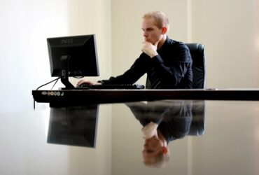 Business professional analyzing data on desktop computer for agricultural or cattle market insights.